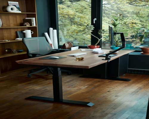 A well-lit comfortable home office setup on a wooden desk
